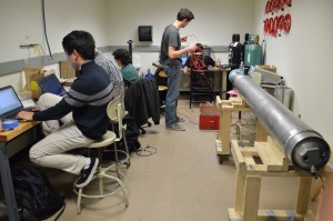 The electronics room in the rocket lab during the bustle of the night before a test with part of the rocket on the right. Photo by Jake Lucas